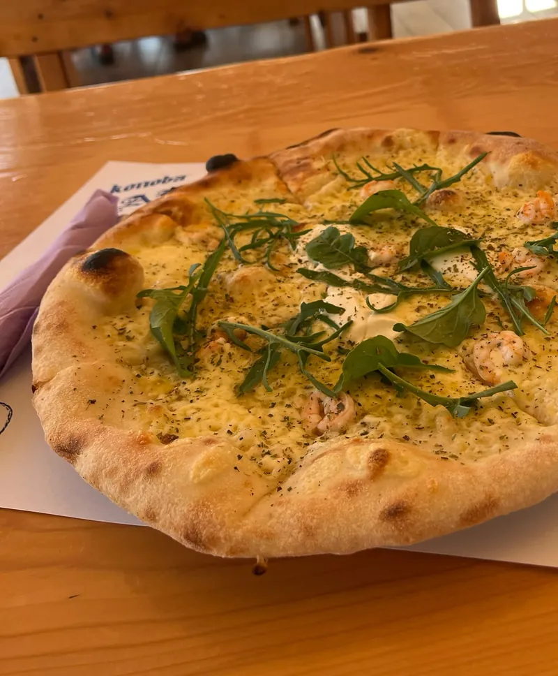 Pizza s rukolom na stolu terase konobe Bare